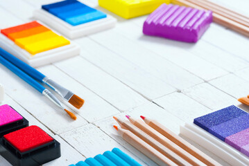 plasticine blocks, ink pads and pencils, brushes on white wood table
