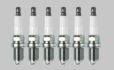 Six spark plugs isolated on gray background.
