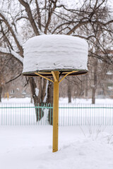 The construction of the sandbox on the playground is covered with snow in winter. Walk around the city in Siberia.