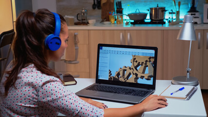 Design engineer working on a 3D component in CAD program on laptop from home. Industrial female employee studying prototype idea on personal computer showing cad software on device display