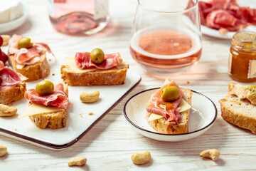 Appetizers and open sandwiches with Italian antipasti, camembert, Parma ham and rose wine