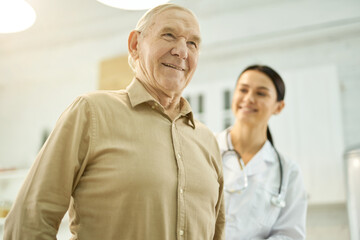 Obraz premium Cheerful elderly man being examined by a medical worker