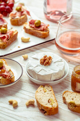 Appetizers and open sandwiches with Italian antipasti, camembert, Parma ham and rose wine