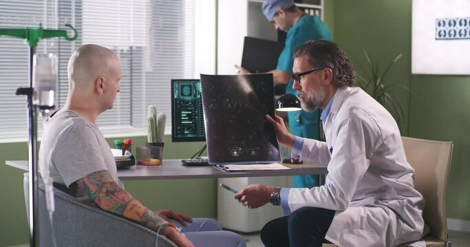 Oncologist showing CT image to cancer patient during chemotherapy