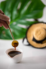 Famous Miel de palma (palm honey or palm syrup) on white background with palm leaf and traditional Canarian hat .
