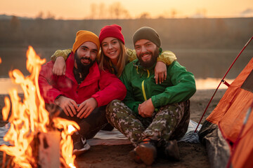 Group of travelers resting near campfire
