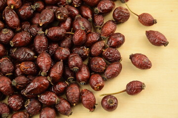 Rose hips, dried wild rose fruits on natural wooden background, super food, healthy fruits, vitamin...