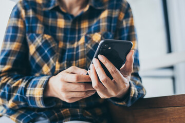 using cell phone hand holding mobile texting message contact us.chatting,search internet information in office.technology device communication connecting.