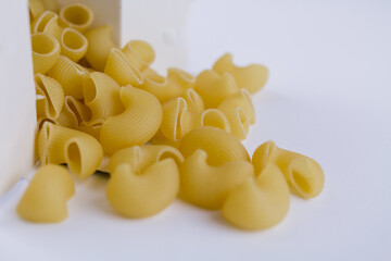 Italian durum wheat pasta poured from a white box on the table