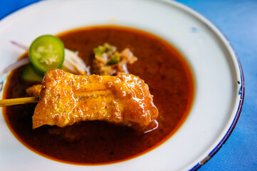 grilled pork satay with peanut sauce and vinegar on table