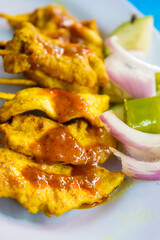grilled pork satay with peanut sauce and vinegar on table