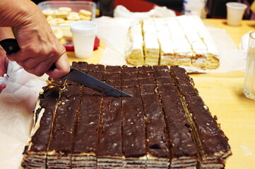 Cropped photo of hand cutting chocolate brownie