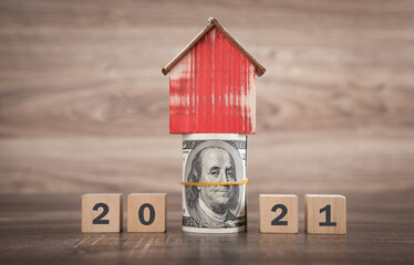 2021 on wooden cubes, house and money.
