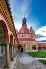 Naklejka premium Jindrichuv Hradec, Czech Republic - September 26 2019: View of the rondel with a pink facade in the garden of the castle. Green lawn and paving on the ground. A sunny day with blue sky and clouds.