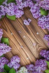 Lilac flowers on a wooden background as a frame, idea, concept backdrop texture.