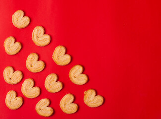 cookies in the form of hearts on a red background, copy space