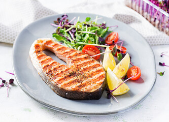Salmon. Salmon fish steak grilled and tomatoes salad with microgreens. Healthy food.