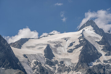 Fototapeta na wymiar Emergency helicopter rescue skier hanging by rope from Grossglockner glacier in Austria summer