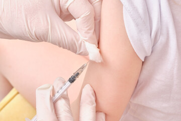 Obraz na płótnie Canvas A doctor makes a vaccination to a child