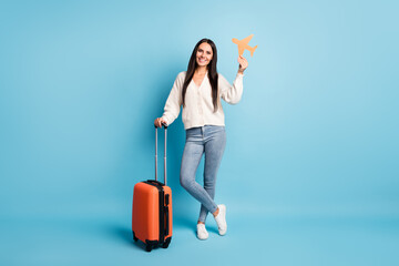 Full body photo of charming person hand hold plane paper card suitcase isolated on blue color background