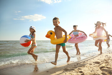 Cute children enjoying sunny day at beach. Summer camp