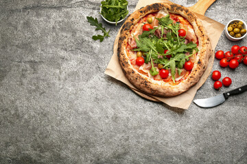 Tasty pizza with meat and arugula on grey table, flat lay. Space for text