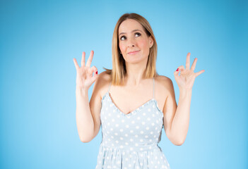 Beautiful woman standing over isolated background doing okay sign with fingers, excellent symbol.