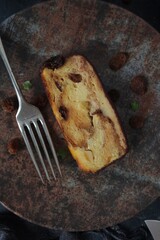 Bakery panettone pudding cake with raisins and chocolate on dark background. Top view with copy space.