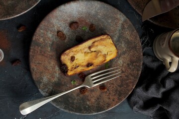 Bakery panettone pudding cake with raisins and chocolate on dark background. Top view with copy space.