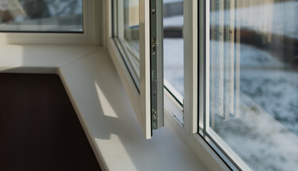 Sash of a plastic balcony window. The frame is white,the sash is slightly ajar.