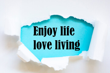 Enjoy life love living. Words written under torn paper. Motivation concept text.