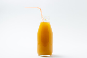 Glass bottle with juice on a white background. Natural mango juice. Refreshing drink