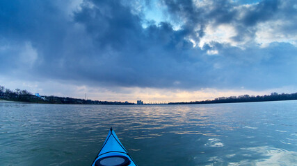 Kayaking in peaceful water of morning river during a cloudy winter day. View from the point of rower © watcherfox