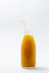 Glass bottle with juice on a white background. Natural mango juice. Refreshing drink