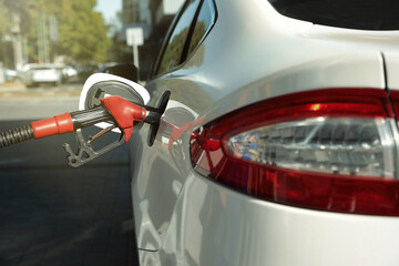Refueling modern car with petrol pump on gas station, closeup