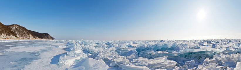 Panorama of the ice hummock field on the frozen Lake Baikal. Piles of snow-covered debris of blue...