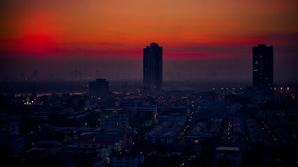 Fototapeta premium The high angle background of the city view with the secret light of the evening, blurring of night lights, showing the distribution of condominiums, dense homes in the capital community