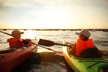 Little children kayaking on river. Summer camp activity