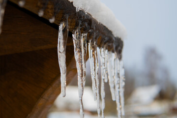 Icicles on roof with snow. Safety tips for icicles.