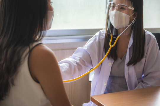 Medical Staff Examine The Patient To Listening The Heart Beat Sound By Using Stethoscope. The ENT Ear Nose Throat Touching To Check Up The Young Illness.