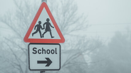 School crossing sign on a foggy morning
