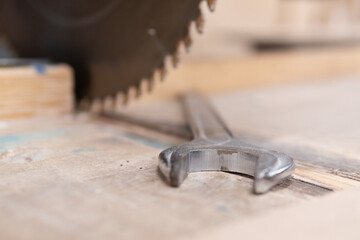 Wrench in front of saw. Blurry woodworking saw. Not safe work. Unsafe work,