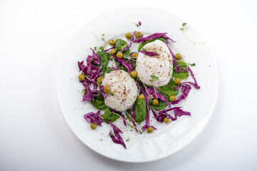 Cooked poached eggs and salad. White plate on a white background.