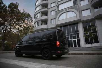 Black delivery van parked on street near building © New Africa
