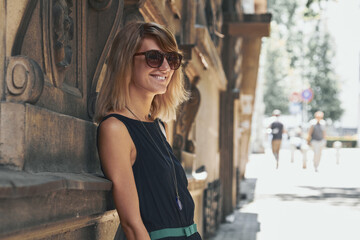 Woman posing on the street sidewalk.