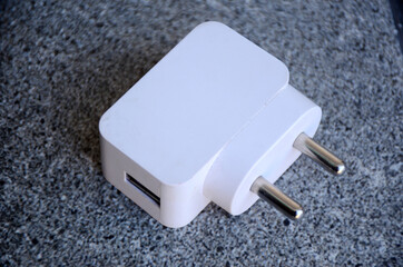 the white color mobile charger adepter on the grey background.