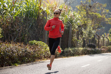 Fitness woman runner running on winter park trail