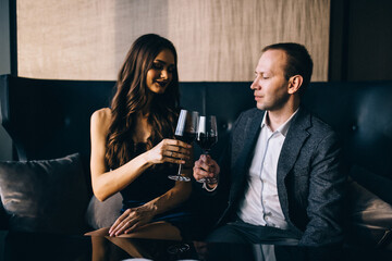 Portrait of amorous young couple toasting with red wine