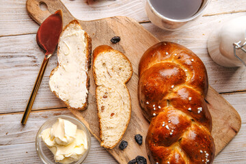 Top view on sweet raisins bun pigtail bread on the decorated wooden background
