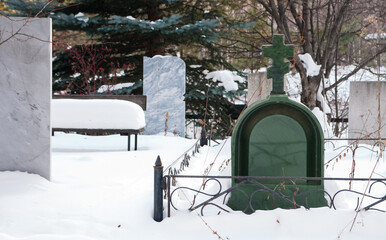 big tombstone on a graveyard in winter time
